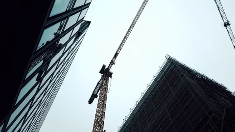 Construction site. It shows two huge cranes lifting construction materials. 4k Stock Footage 102080329