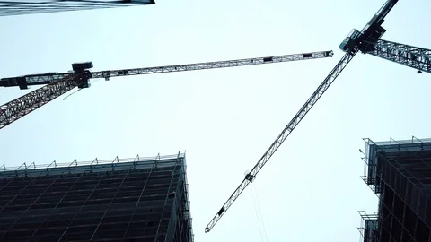 Construction site. It shows two huge cranes lifting construction materials. 4k Stock Footage 102080693
