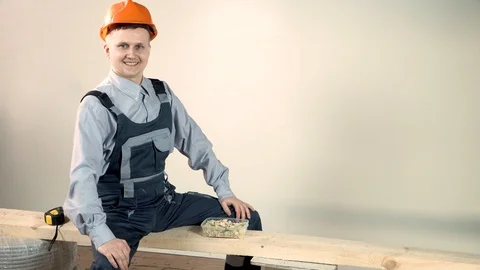 At the construction site it was lunch time. The young builder decided to eat a l Stock Footage 102777376