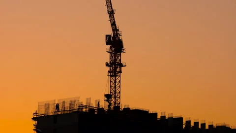 The construction site of a large apartment building. Silhouettes of workers  Stock Footage 164336156