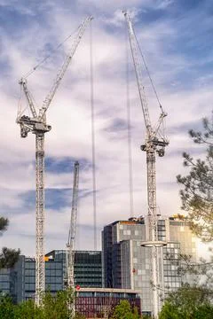 Construction site with large cranes towering into the sky Stock Photos