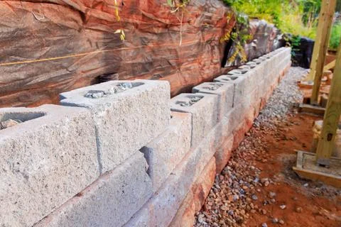 Construction site line of concrete blocks arranged for retaining wall buildin 스톡 사진