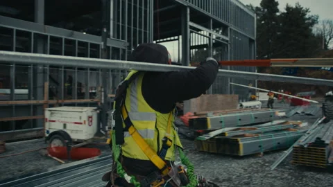 Construction Site: Man carries beam 스톡 동영상 224964139