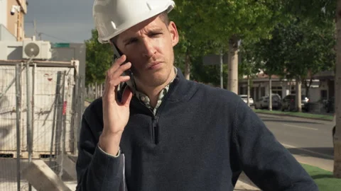 Construction site manager talking on smartphone outdoors. Professional coor.. Stock Footage 329642620