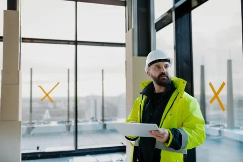 Construction site manager using digital tablet to inspect building progress. Stock Photos
