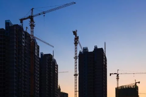Construction site with many cranes at sunset Stock Photos