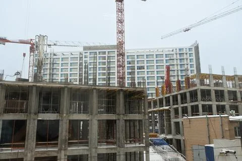 Construction site of a multi-storey building. Winter time. Several workers work Stock Photos