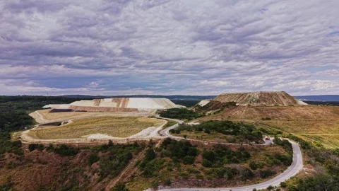 Construction site near hills with cloudy sky during day Stock Footage 339649898