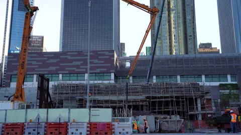 Construction site of a new building with workers and a crane next to a Stock Footage 147142975