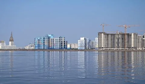 Construction site of new buildings, view from the river to the new neighborho Stock Photos