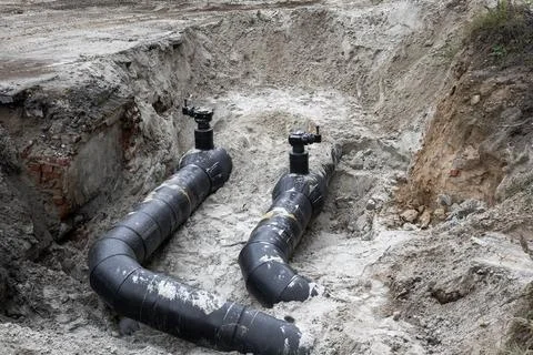 Construction site with newly installed underground pipes in a trench Photos