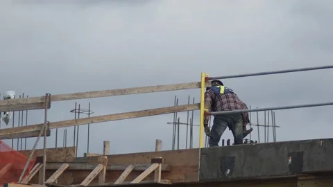 Construction site one worker with hat roofer working on top of building Stock Footage 165231443