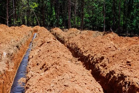 Construction site open trenches for drainage installation in forest area Stock Photos