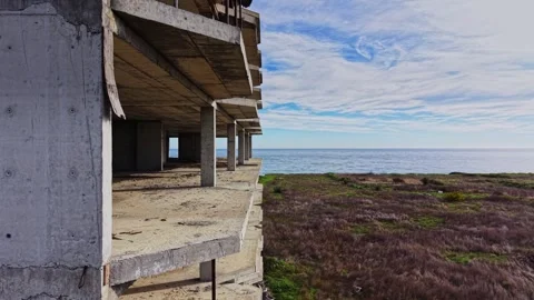 Construction site overlooking the ocean with clear sky and grassy area Video stock 325085434
