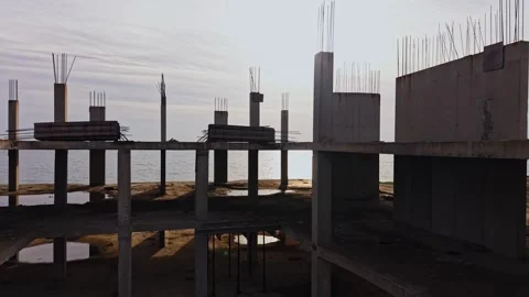 Construction site overlooking the ocean in daylight with unfinished pillars Stock Footage 324520635