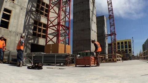 Construction Site Pan Right to Materials and worker Stock Footage 81457388