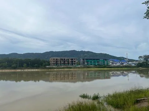 Construction site with partially completed buildings reflected in a lake, s.. Stock Photos