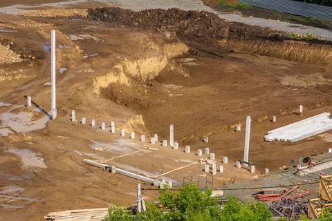 Construction site with a pit in several levels of the bottom, several piles of Stock Photos