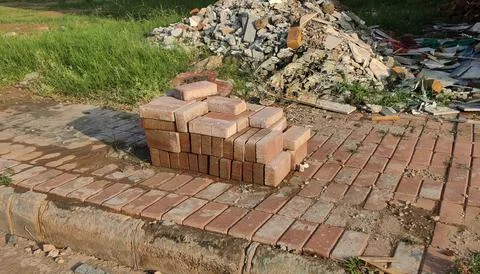 Construction site with red bricks and rubble near dry grass in daylight 写真素材