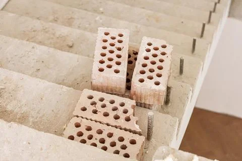 Construction site with red bricks placed on concrete stairs, showing unfini.. Stockfoto's