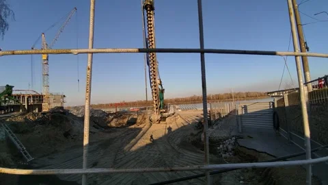 Construction site by river with cranes and machinery Stock Footage 333471992