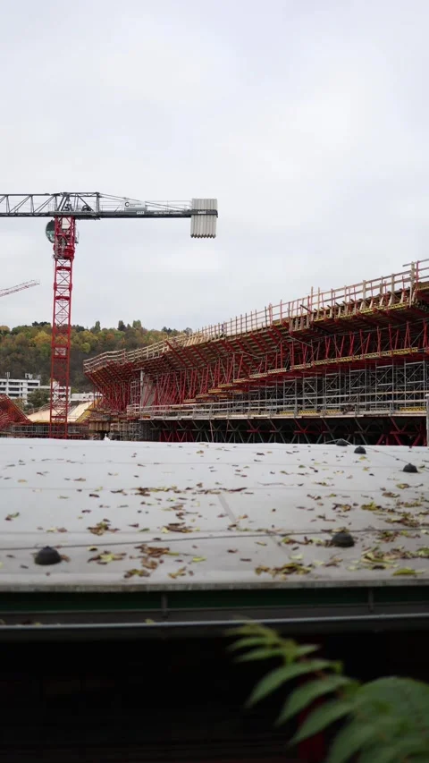 Construction site by the river with a large red crane and massive metal framewor Stock Footage 289644883
