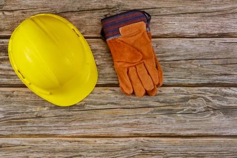 Construction site safety protective hard hat safety gloves on wooden backgrou Stock Photos