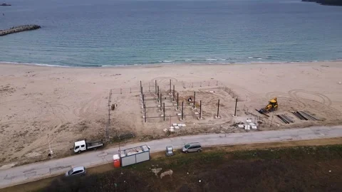 Construction site on a sandy beach near the sea, featuring structural Stock Footage 300258013