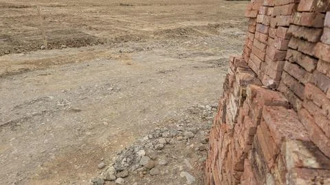 A construction site scene with a stack of red bricks on the right. The fore.. Stock Photos