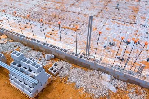 Construction site showcasing foundation work with concrete blocks and steel Stockfoto's