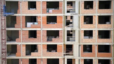 Construction site showing building frame and red bricks during construction.. Fotos de archivo