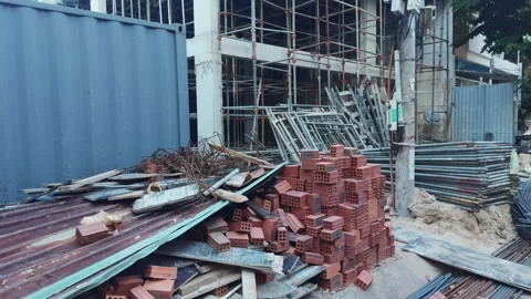 Construction site showing building materials like bricks, metal scaffolding, Vídeos de archivo 336553957