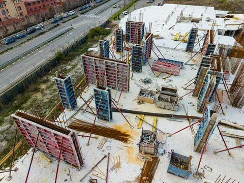 Construction site showing building process with scaffolding and materials near a Stock Photos