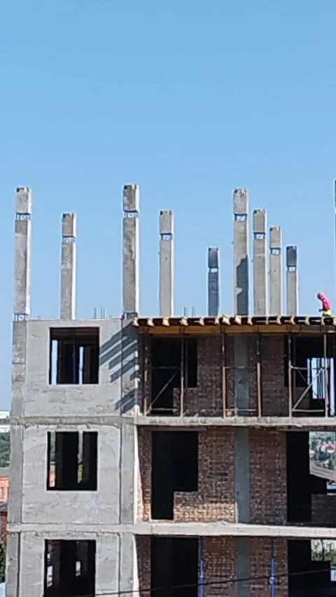 Construction site showing concrete pillars and brick walls in progress under Stock Footage 340606741