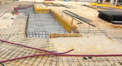 Construction site showing foundation work with rebar and gravel in urban ar.. Stock Photos
