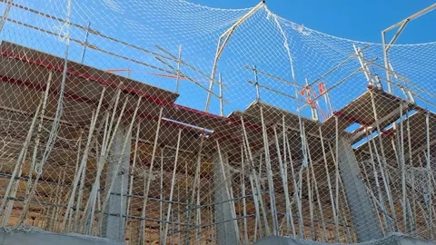 Construction site showing scaffolding and safety nets surrounding the build.. Video stock 337344865