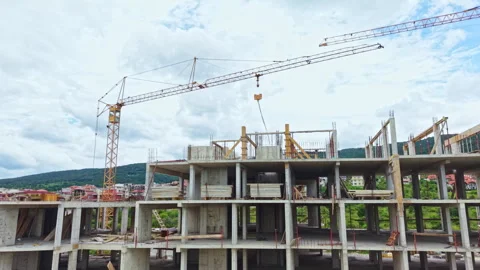 Construction site shows a building being constructed with cranes and workers on Stock Footage 337892973