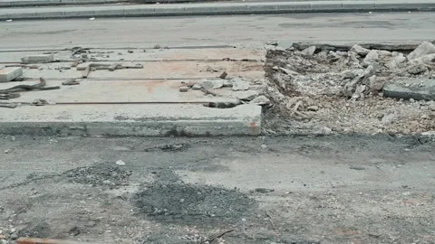 A construction site shows damage to the roadway with sections of broken pavement Stock Footage 339095823