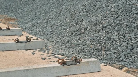 Construction site shows workers preparing gravel for a project near large piles. Видео 344675826
