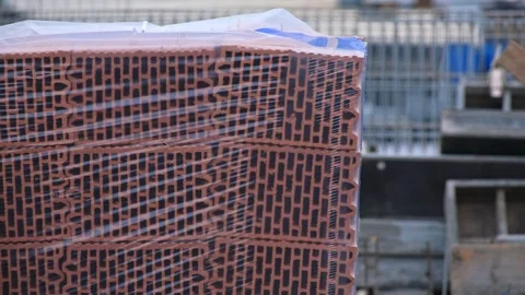 Construction Site with Stack of Red Clay Cinderblock Hollow Bricks Wrapped Stock Footage 327763702