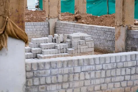 Construction site with stacked bricks and foundation walls Stockfoto's