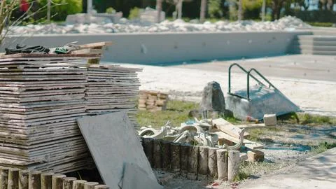 Construction site with stacked materials and tools on a sunny day Stock Photos