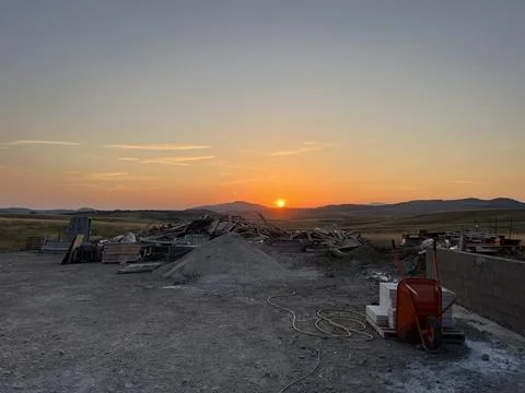 Construction Site at Sunset, Building Materials and Wheelbarrow Fotos Stock