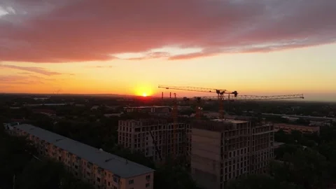 Construction site at sunset with cranes and buildings under development Stock Footage 339123945