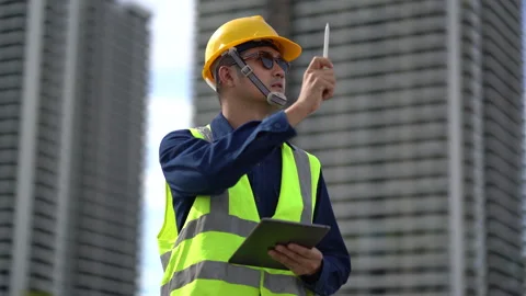 Construction Site Supervisor: A focused construction worker, wearing a safe.. Stock Footage 297598650