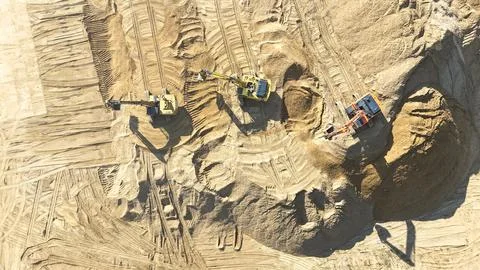 A construction site with three large yellow machines Stock Photos