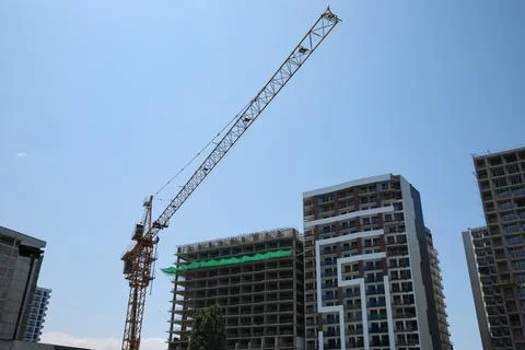Construction site with tower crane near unfinished building, low angle view Stock Photos