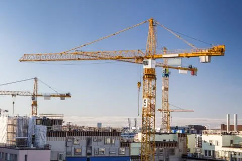 Construction site with tower cranes against clear sky. Stock Photos