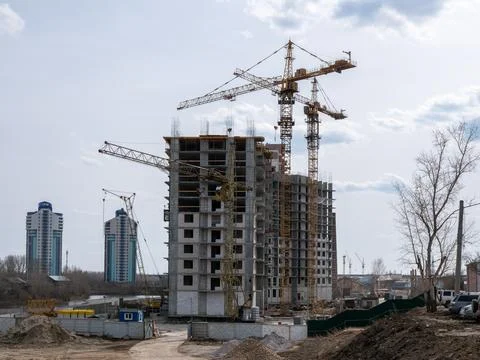 Construction site with tower cranes and high-rise building under development  Stock Photos