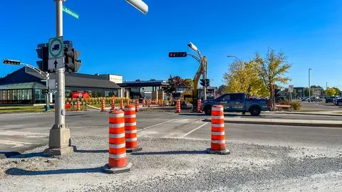 Construction site with traffic cones and machinery, showcasing roadwork and Stock Photos